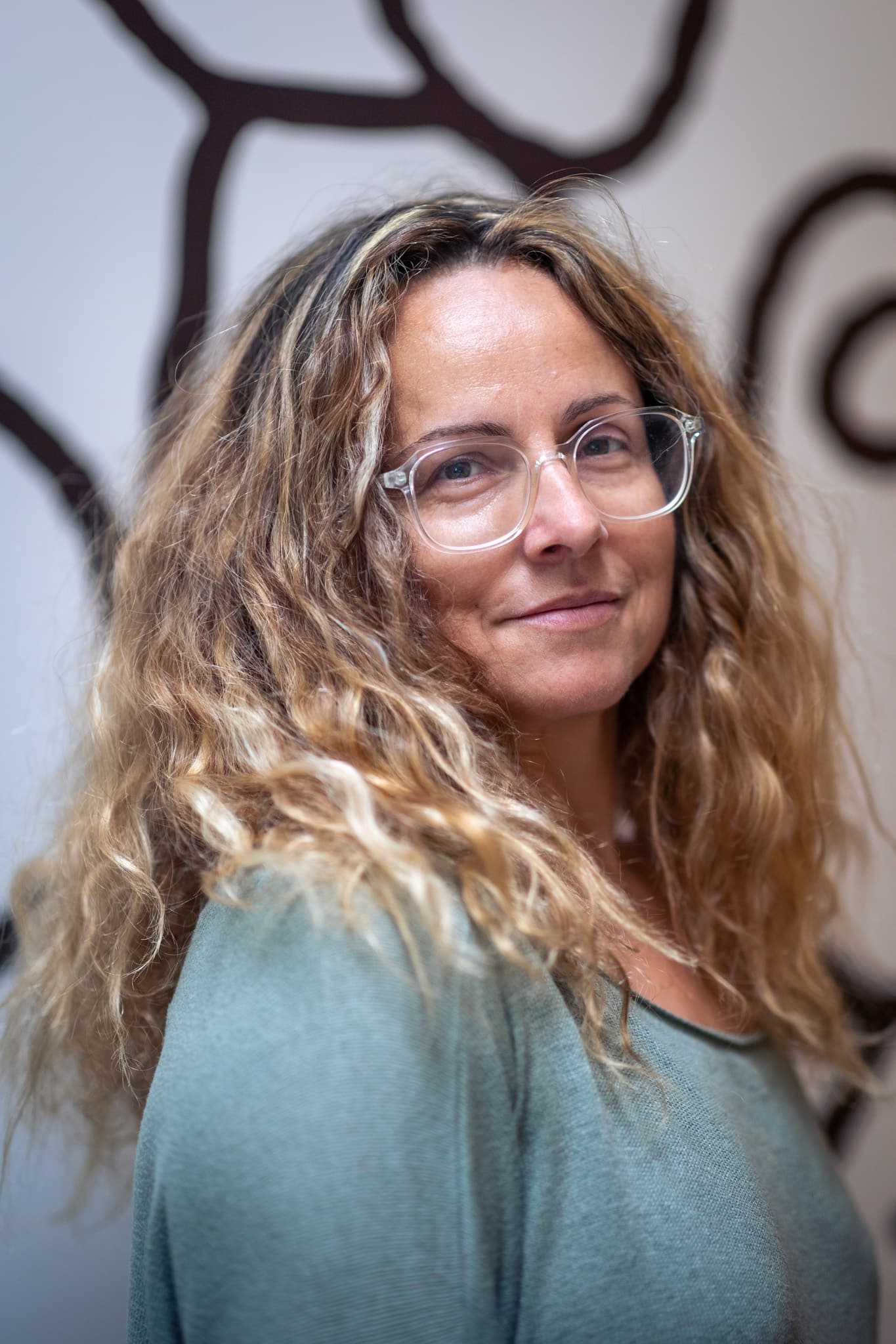 Lisbeth, responsable de l'organisation ou assistante de direction chez l'agence web Azuracom, souriante et professionnelle dans les bureaux.