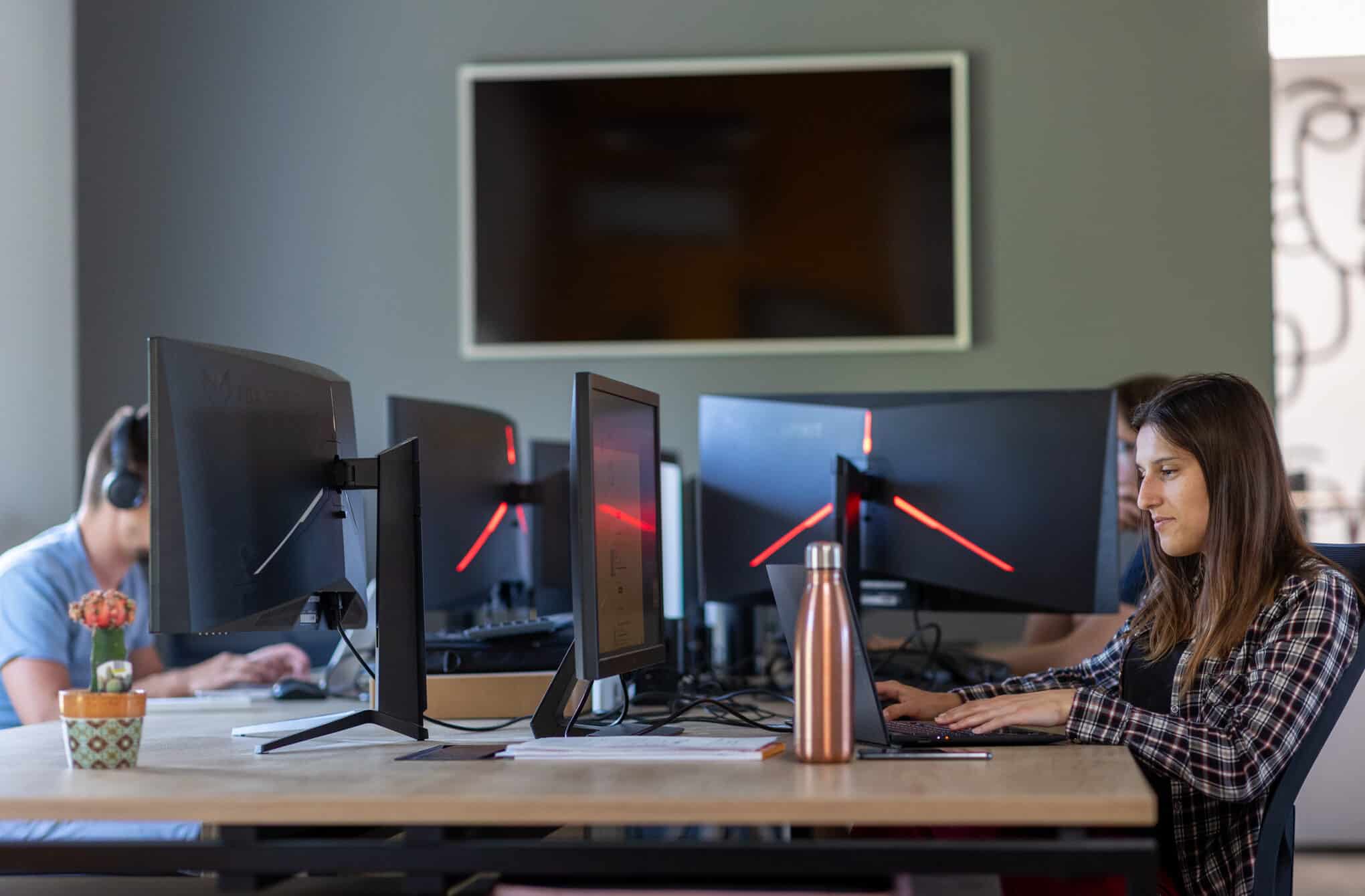 Equipe-dev L'équipe de développeurs de l'agence de développement web Azuracom travaillant sur des ordinateurs. Collaboration technique et concentration.