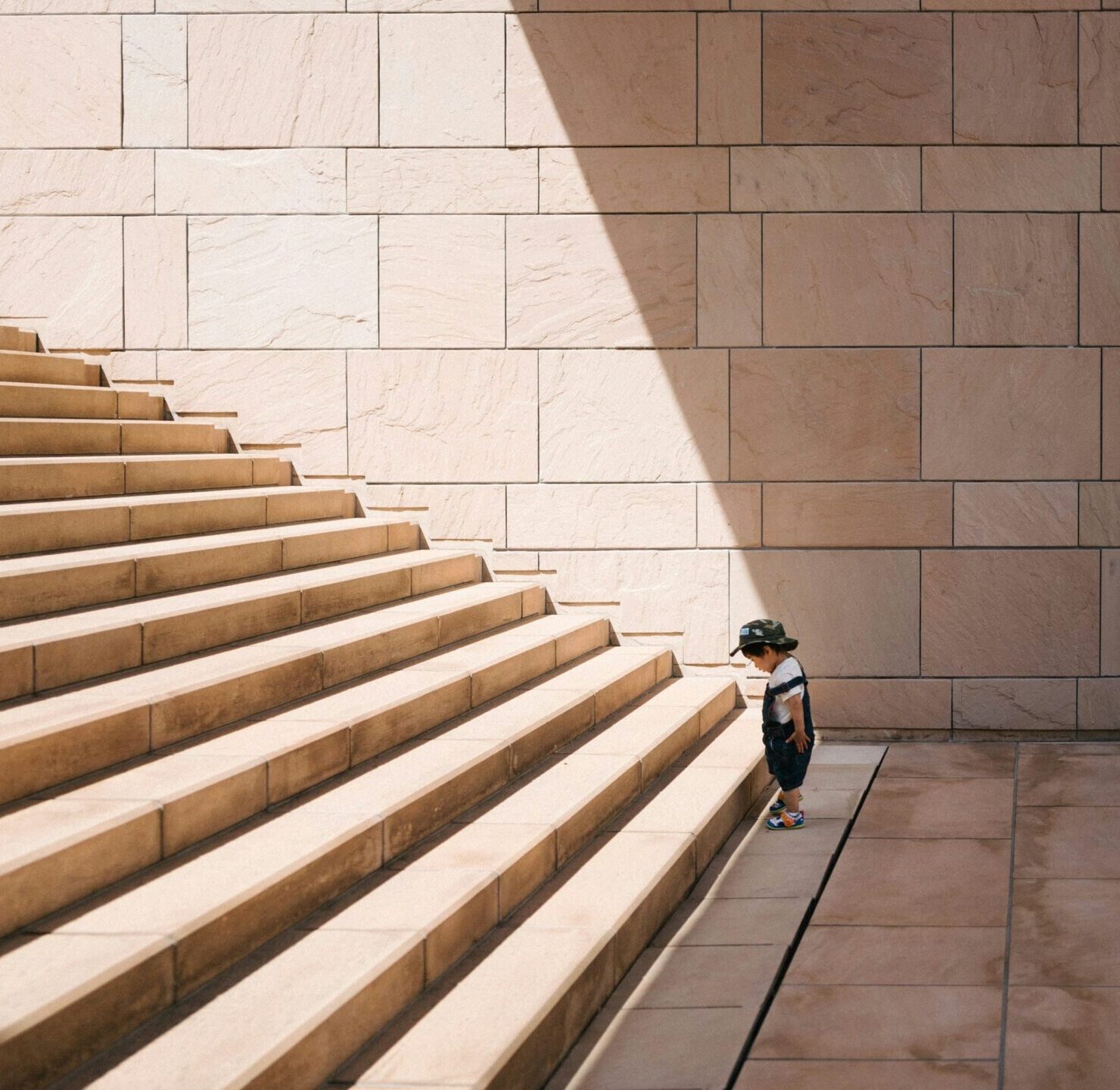 Photo d'un enfant devant des marches d'escalier, symbolisant la méthodologie et les étapes claires de la stratégie digitale (SEO et croissance) de l'agence Azuracom.