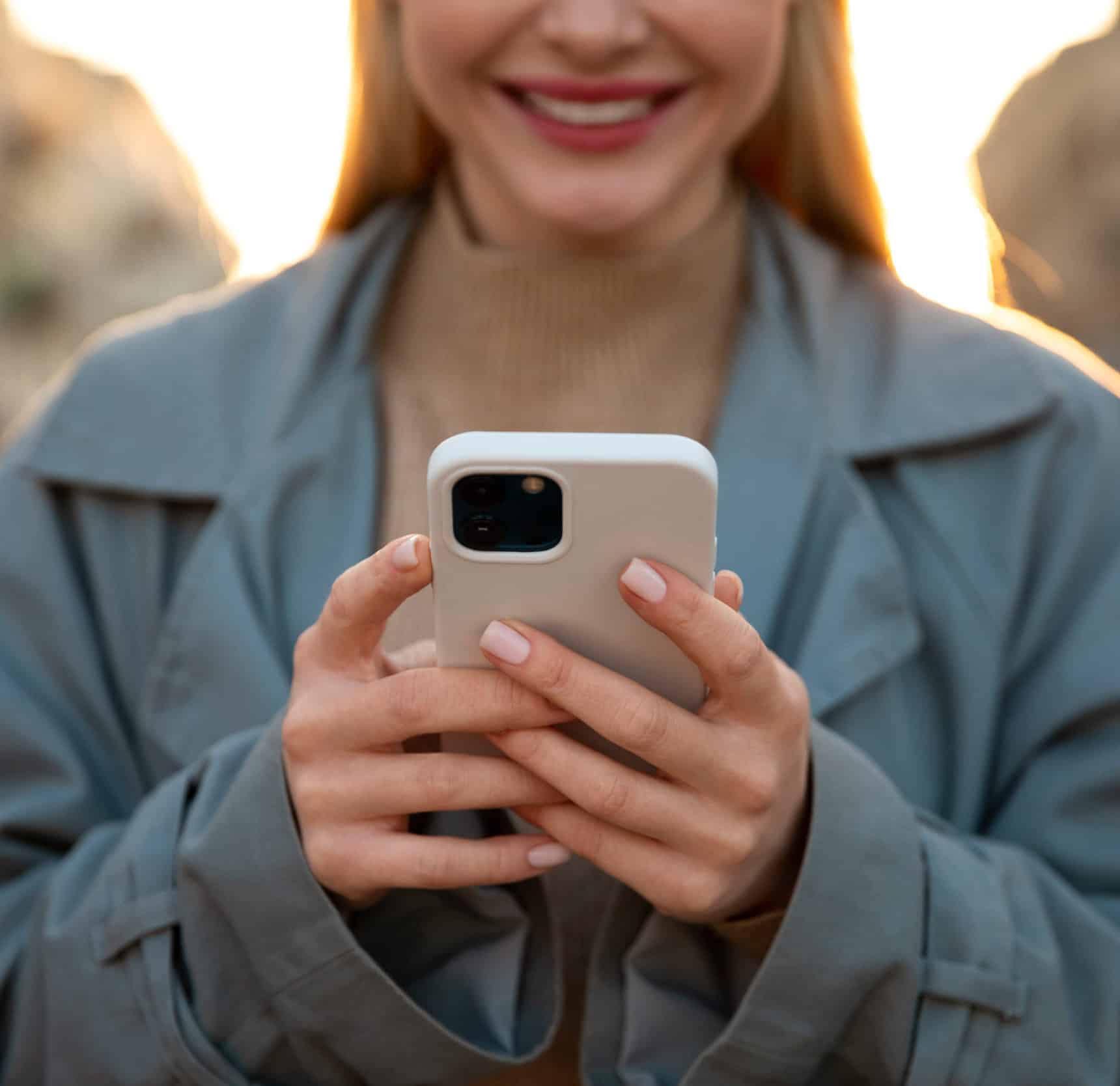 Femme utilisant un smartphone pour contacter l'agence web Azuracom via le formulaire de contact.