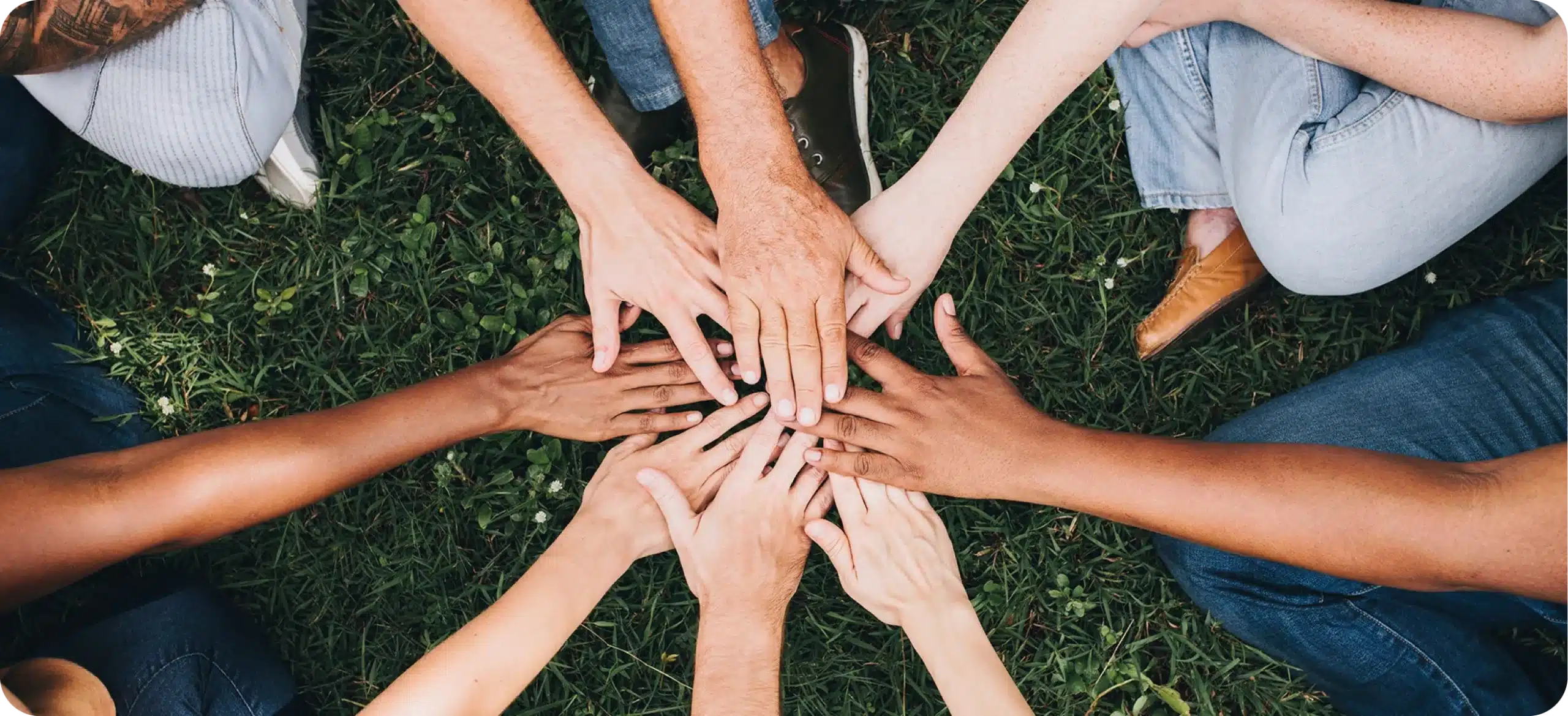 Ensemble de mains de différentes couleurs se touchant, illustrant l'inclusion, la diversité et l'engagement pour l'accessibilité numérique (RGAA) de l'agence web Azuracom Avignon.