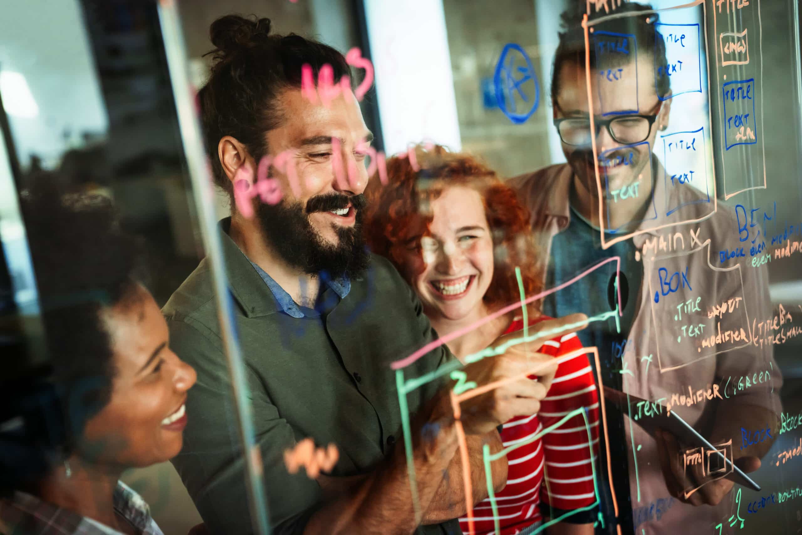 Réunion de développeurs de l'agence de développement web Azuracom écrivant des lignes de code sur un tableau en verre, favorisant la collaboration et le brainstorming technique.