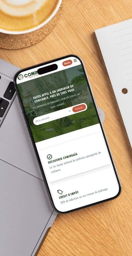 mobile-homepage smartphone posé sur un ordinateur portabel montrant la page d'accueil de Comingaïa, la première plateforme des jardiniers paysagistes de France