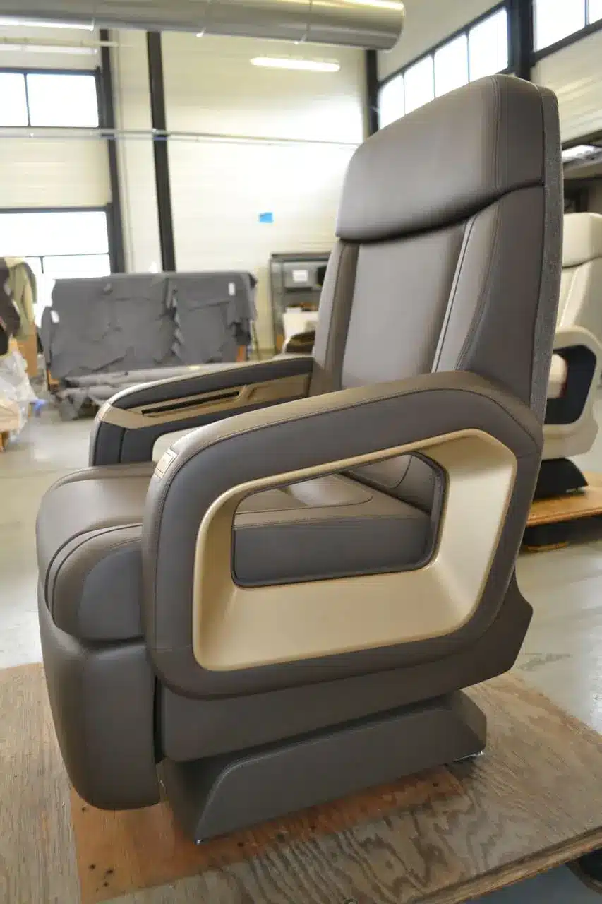 Fauteuil en cuir haut de gamme en cours d’assemblage dans un atelier, illustrant le niveau de finition présenté sur un site vitrine luxe.