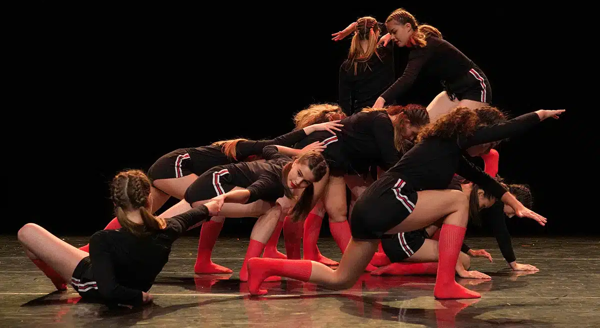Formation chorégraphique Groupe de danseuses en formation chorégraphique au sol et en appui, photographie provenant du site web du Lieu Danse, utilisée dans un contenu relatif au développement logiciel métier.