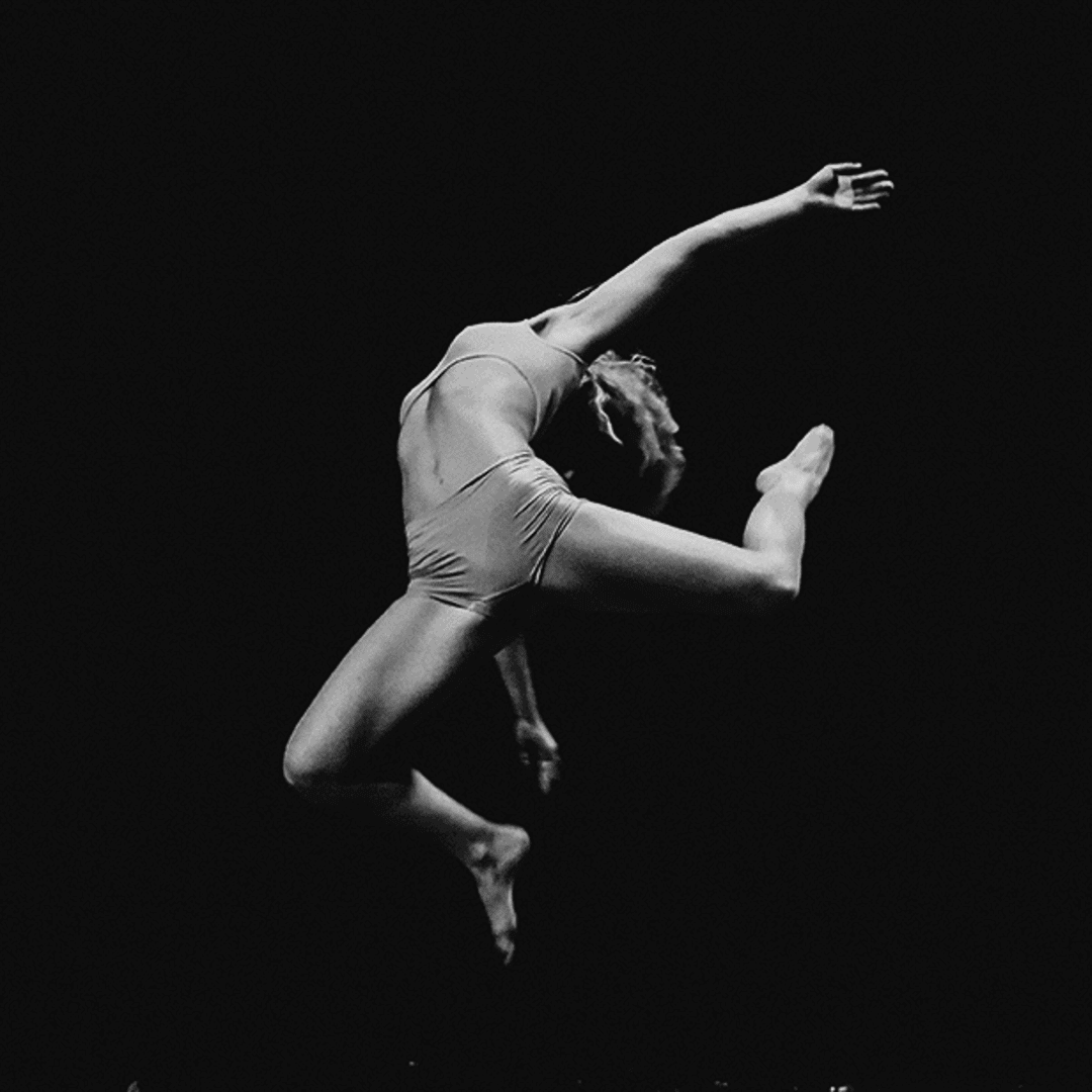 Danseuse en saut — visuel du Lieu Danse Danseuse capturée en plein saut sur fond noir, image issue du site web du Lieu Danse,pour lequel l'agence web Azuracom a développé un logiciel métier.