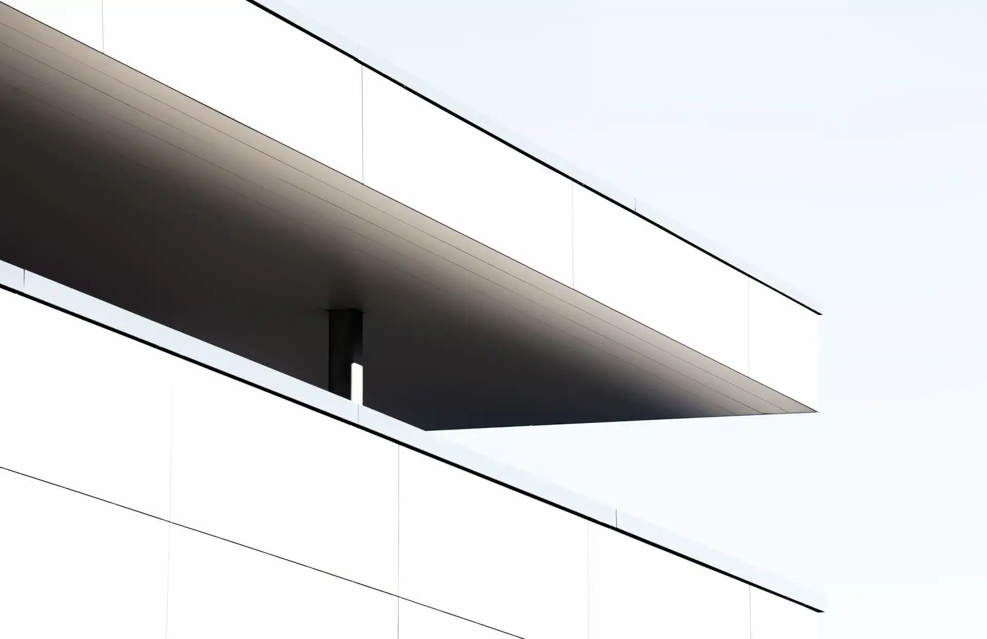 facade-moderne-minimaliste Façade minimaliste d’un bâtiment moderne composée de larges panneaux blancs et d’un porte-à-faux géométrique créant une ombre marquée ; illustration utilisée dans un contexte lié à la création de plateforme de gestion d’adhérents