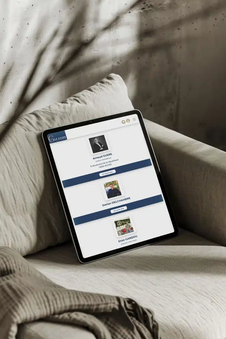 Tablette posée sur un fauteuil affichant des profils d’agents immobiliers sur une plateforme en ligne, illustrant la valeur d’une création site immobilier sur mesure pour présenter une équipe de manière claire et professionnelle
