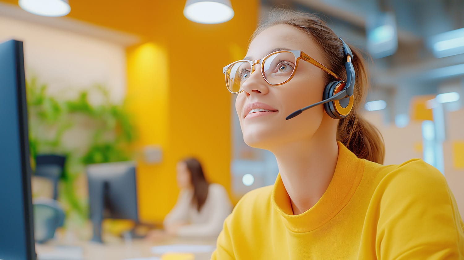 crm-service-client Conseillère en service client avec casque micro travaillant sur ordinateur dans un open space moderne, illustrant le rôle d’un intégrateur CRM et la gestion de la relation client.